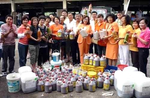 Nyonya Kitchen staff and community members with bottled eco-enzyme